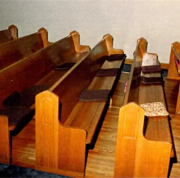 Wooden pews with old, mismatched loose cushions before upholstery